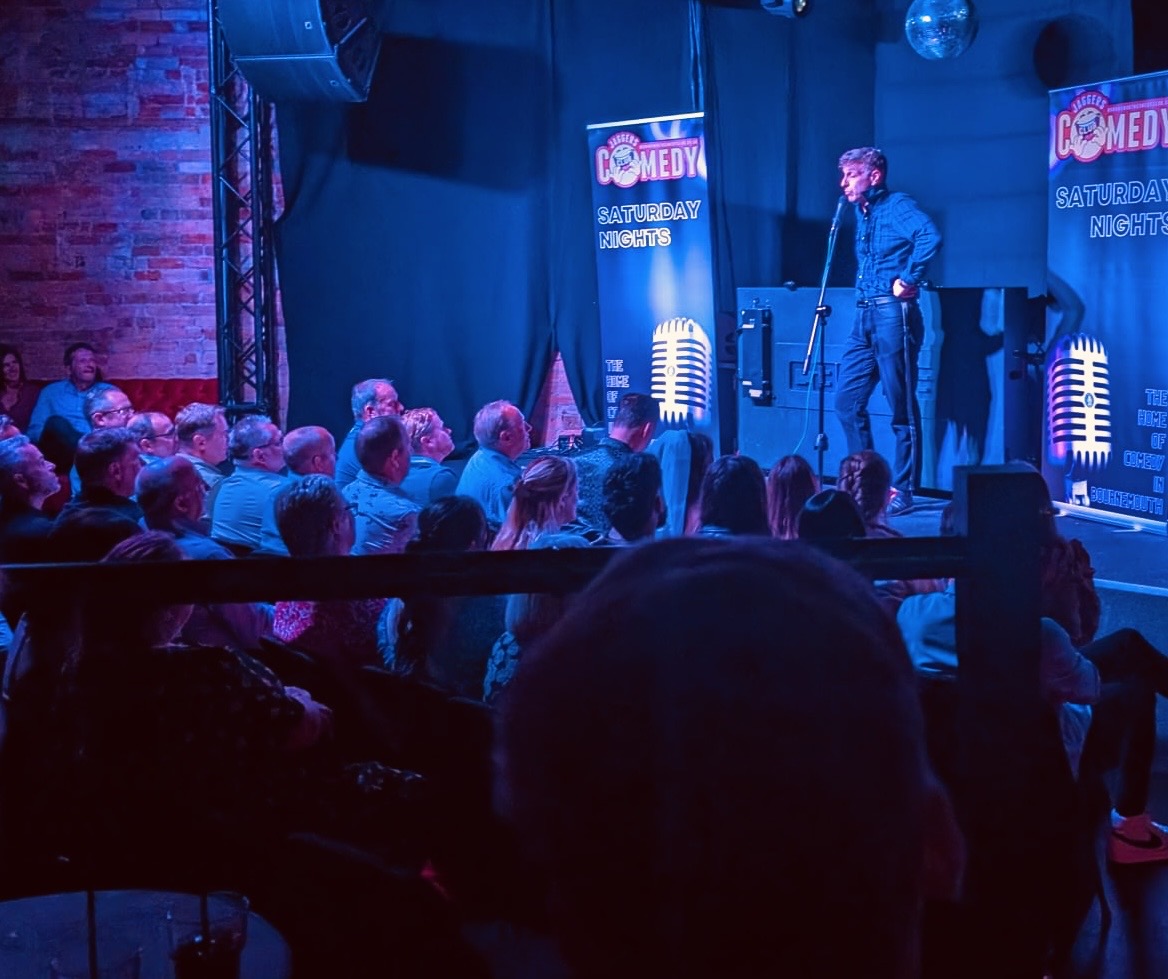 Electric atmosphere at live comedy show with blue lighting and engaged Bournemouth audience